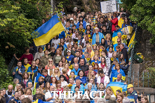 우크라이나의 독립기념일인 24일(현지시간) 영국 스코틀랜드 에든버러 칼튼 힐에 모인 사람들이 우크라이나 국기를 흔들며 응원의 목소리를 전하고 있다. /스코틀랜드=AP.뉴시스
