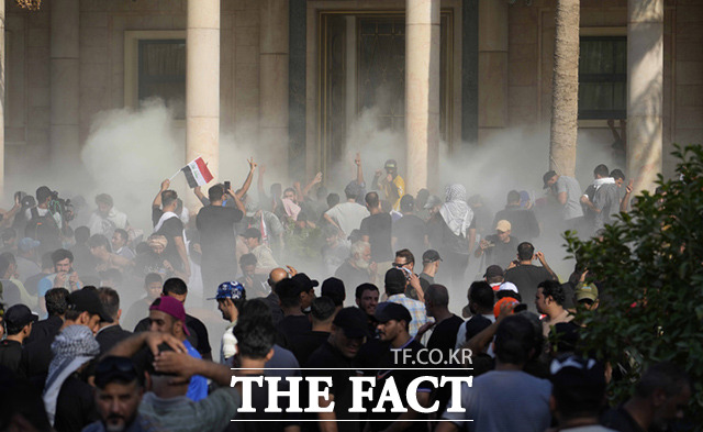 이라크의 시아파 성직자 겸 정치인인 무크타다 알 사드르의 지지자들이 29일(현지시간) 이라크 바그다드 시내 그린존에 있는 정부청사에 보여 시위하자 이라크 보안군이 최루탄을 쏘고 있다. /바그다드=AP.뉴시스