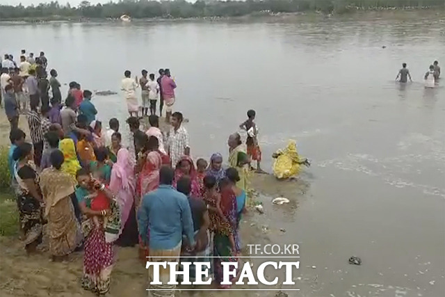 25일(현지시간) 방글라데시 판차가르주 카라토야강에서 선박이 전복된 가운데 사람들이 현장을 수색하고 있다. /판차가르=AP.뉴시스