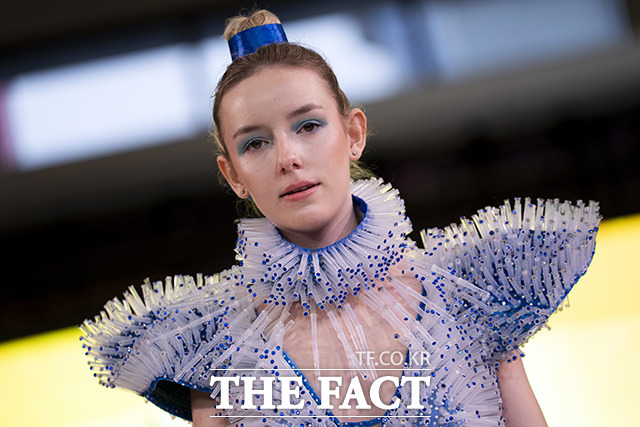 지난 15일(현지시간) 네덜란드 로테르담에서 열린 패션쇼에서 한 모델이 코로나19 백신 주사기 커버와 얀센 백신 뚜껑으로 만든 드레스를 착용하고 런웨이를 걷고 있다. /로테르담=AP.뉴시스