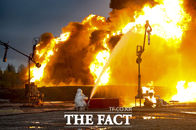 27일(현지시간) 우크라이나 동부 도네츠크주 샤흐타르스크의 한 석유 창고가 우크라이나군 폭격으로 화재가 발생한 가운데 소방관들이 유조열차에 붙은 불을 진압하고 있다. /샤흐타르스크=AP.뉴시스