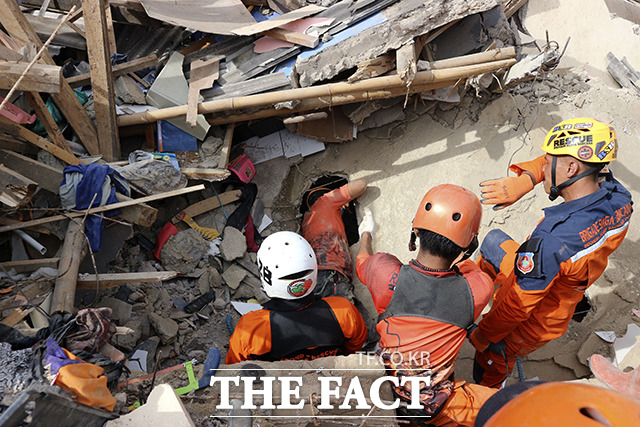23일(현지시간) 인도네시아 서자바주 치안주르에서 구조대원들이 지진으로 무너진 주택 잔해 속에서 실종자를 수색하고 있다. /치안주르=AP.뉴시스