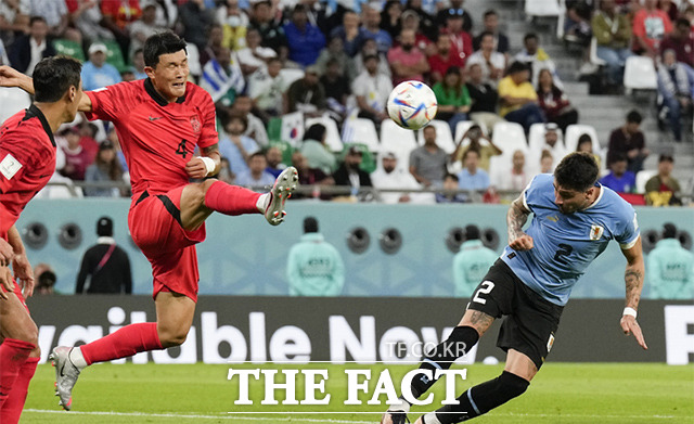 지난 24일 카타르 알라얀에서 열린 우루과이와 한국의 월드컵 H조 조별리그 축구 경기에서 한국의 김민재(왼쪽)가 수비하면서 공을 헤딩하고 있다. /알라이얀=AP.뉴시스