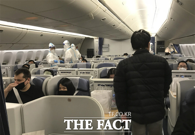 24일(현지시간) 미국 뉴욕의 JFK공항에서 중국으로 향하는 여객기에서 승무원들이 방호복을 입고 근무하고 있다. /뉴욕=AP.뉴시스