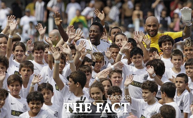 2012년 4월 14일 브라질 산토스에서 열린 팀의 100주년 기념행사에서 손들 흔들고 있는 펠레(가운데 톱)와 그의 아들 에드손 콜비 두 나시멘토(오른쪽 위). /산투스=AP.뉴시스