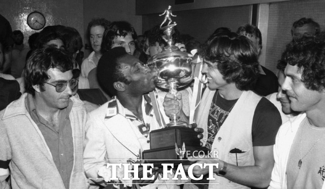1977년 8월 29일자 파일 사진에서 뉴욕 코스모스의 축구선수 펠레(가운데)가 팀 주장 베르너 로스가 들고 있던 팀의 트로피에 입을 맞추고 있다. /뉴욕=AP.뉴시스