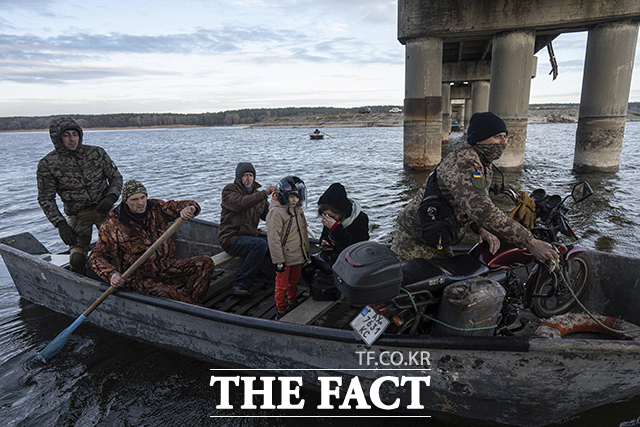 히르키우주에서는 다리가 파괴되면서 주민들이 군인의 도움을 받아 작은 배를 타고 시베르스키 도네츠강을 건너고 있다. /스타리 살티우=AP.뉴시스
