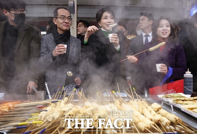 윤석열 대통령 부인 김건희 여사가 11일 대구 서문시장을 찾아 어묵을 시식하며 상인들과 대화하고 있다. /뉴시스