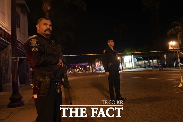 22일 미국 캘리포니아 몬테레이 파크에서 발생한 총격사건 현장에서 두 경찰관이 경계를 서고 있다./AP.뉴시스