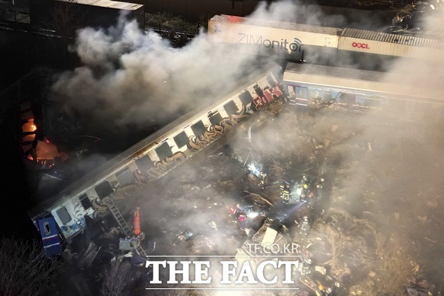 28일(현지시간) 밤 그리스 수도 아테네 북쪽 템피 인근에서 화물열차와 여객열차가 충돌, 탈선과 화재가 발생해 소방관과 구조대원들이 구조작업을 하고 있다./AP 뉴시스