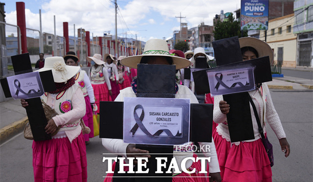 세계 여성의 날인 8일(현지시간) 페루 푸노에서 아이마라 원주민 여성들이 과거 피살된 젊은 여성들의 이름과 나이가 적힌 십자가를 들고 행진하고 있다. /푸노=AP.뉴시스