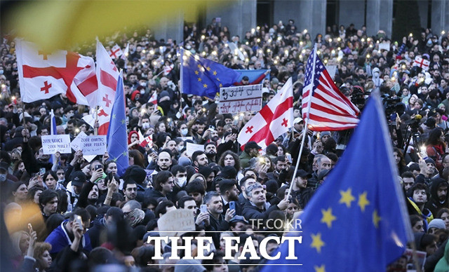 8일(현지시간) 조지아 트빌리시 의회 건물 밖에서 반정부 시위대가 미국, 우크라이나, 조지아 국기와 유럽연합 깃발을 흔들고 있다. /트빌리시=AP.뉴시스