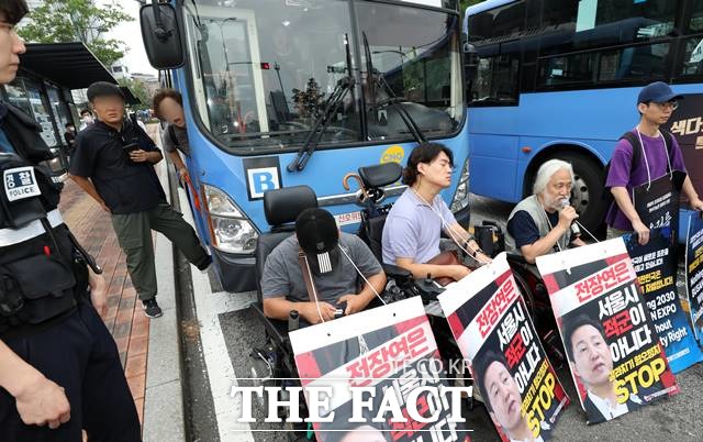 서울시가 대변인 명의 논평을 통해 전국장애인차별철폐연대에 버스 시위에 강력한 법적대응을 예고했다. 13일 오전 서울 종로구 혜화동로터리에서 한 시민이 출근길 버스를 가로막은 박경석 전국장애인차별철폐연대 대표와 회원들에게 항의하고 있다. /뉴시스