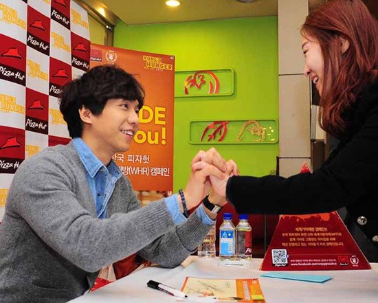 이승기가 28일 열린 팬사인회에서 한 여성팬의 손을 잡아주고 있다./한국 피자헛 제공