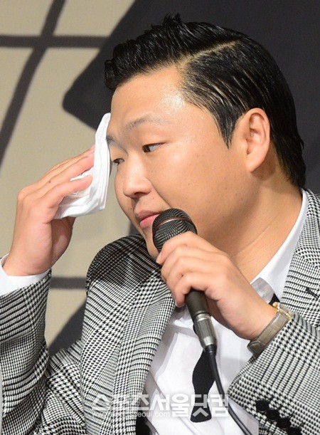 싸이가 기자회견 중 손수건으로 이마에 맺힌 땀을 닦아내고 있다./ 더팩트DB