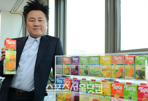 



장웅이 자회사 제품인 팁코 주스를 들고 포즈를 취하고 있다. 
