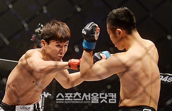 



윤형빈(왼쪽)이 9일 오후 서울 송파구 올림픽공원 올림픽홀에서 열린 '로드FC 14' 라이트급 매치에서 다카야 츠쿠다에게 주먹을 날리고 있다. / 올림픽공원=문병희 기자