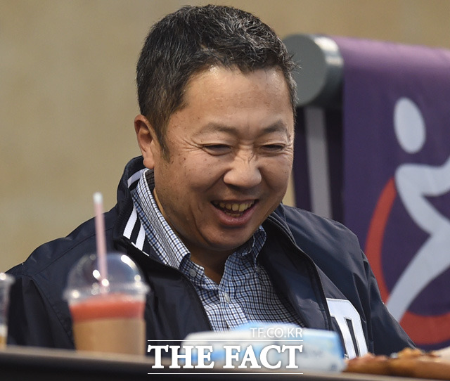 박정원 두산그룹 회장이 관중석에서 그룹 관계자와 대화를 나누다 활짝 웃고 있다.