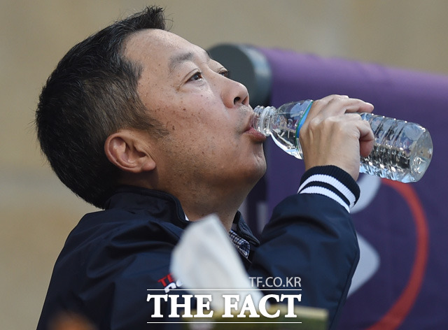 박정원 두산그룹 회장이 관중석에서 경기를 지켜보며 물을 마시고 있다.
