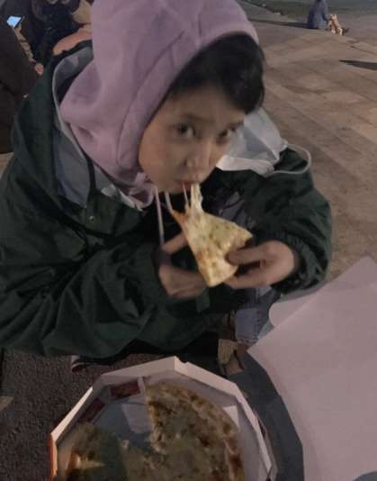 가수 아이유가 거리에서 피자를 먹고 있다. /강한나 SNS