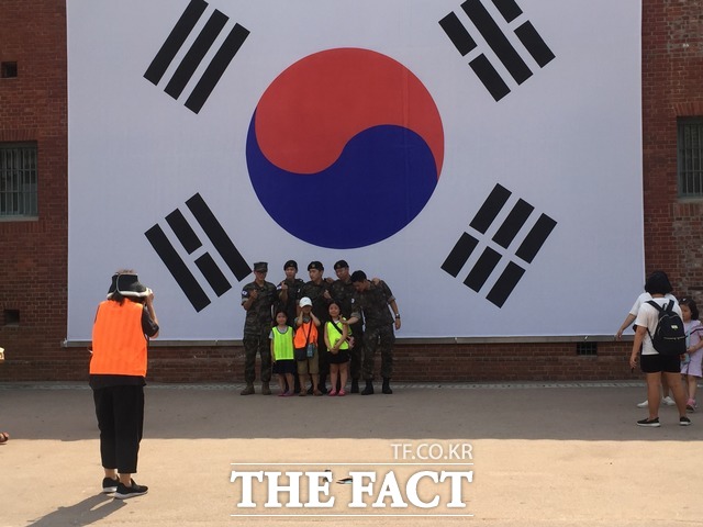 8월 15일 광복절을 앞두고 자유한국당은 '건국절' 논쟁에 불을 지폈다. 그러나 국민과 여야는 '건국' 아닌 '광복'에 무게를 싣고 있다. 사진은 시민과 군인이 이날 서울 서대문형무소역사관에 걸린 태극기 앞에서 함께 기념사진을 촬영하는 모습. /서대문형무소역사관=임현경 인턴기자