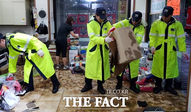 광주 침수, 피해 속출. 폭우 특보가 내려진 27일 오후 광주 남구 백운동 남구청사 인근 상가에서 경찰들이 침수 피해 복구작업을 하고 있다. /광주=뉴시스