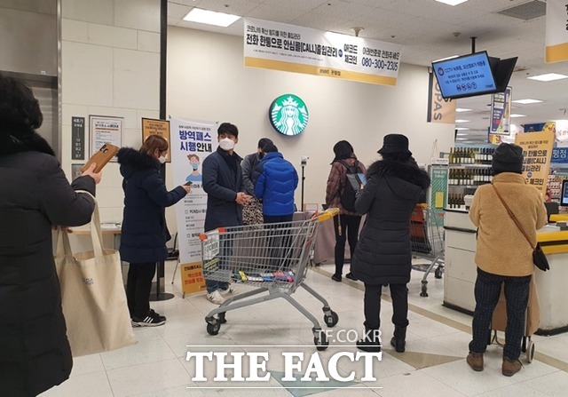 고객들이 마트 입구에서 직원의 도움을 받아 방역패스 접종 증명 절차를 거치고 있다. /응암동=신정인 인턴기자
