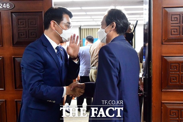 박용진 의원은 당 지도부의 당헌 개정안 재상정 시도를 비판하며 중앙위원회를 재소집할 경우 오프라인으로 해야 한다고 요청했다. 지난 16일 의원총회장 앞에서 참석하는 우상호 비상대책위원장과 인사하는 박 의원. /남윤호 기자