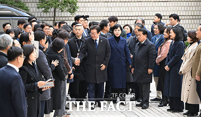 이재명 더불어민주당 대표가 25일 오후 서울 서초구 서울중앙지법에서 열린 위증교사 혐의 1심 선고 재판에 출석하며 동료의원들과 악수를 하고 있다. /사진공동취재단