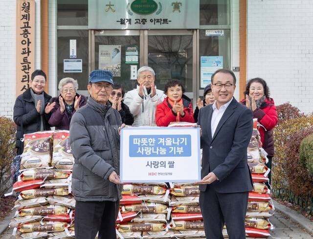 HDC현대산업개발은 매년 연말 릴레이로 진행하는 ‘따뜻한 겨울나기’ 행사의 하나로 서울시 노원구 어르신에게 식료품을 기부하는 전달식을 진행했다. (앞줄 왼쪽부터 김욱진 월계시영고층아파트 입주자대표회장, 신왕섭 HDC현대산업개발 실장). /HDC현대산업개발