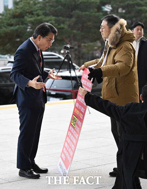 두 번째 윤석열 대통령 탄핵소추안 표결을 하루 앞둔 13일 김상욱 국민의힘 의원이 서울 여의도 국회 본청 앞에서 여당 의원들의 찬성투표를 호소하며 1인 시위를 하는 가운데, 윤상현 국민의힘 의원이 탄핵 표결을 반대하며 김 의원과 설전을 벌이고 있다. /국회=이새롬 기자