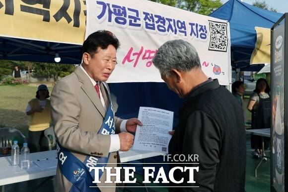 서태원 가평군수(왼쪽)가 지난 4월 한 군민에게 범군민 서명운동을 설명하며 동참을 부탁하고 있다./가평군