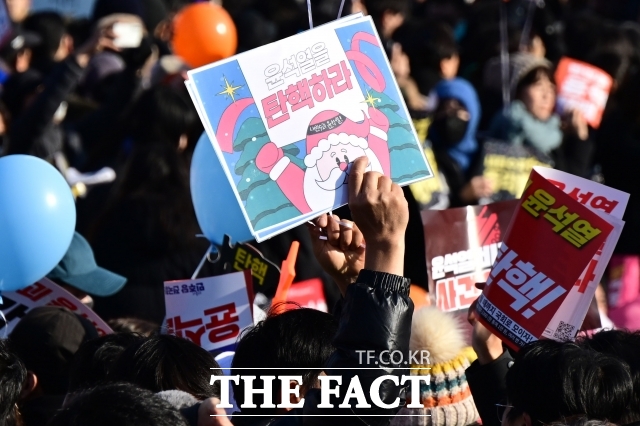 4일 윤석열 대통령 탄핵소추안 표결 앞두고 서울 여의도 국회 앞에서 열린 내란수괴 윤석열 즉각 탄핵! 범국민촛불대행진에서 한 시민이 탄핵 피켓을 들고 있다./남윤호 기자