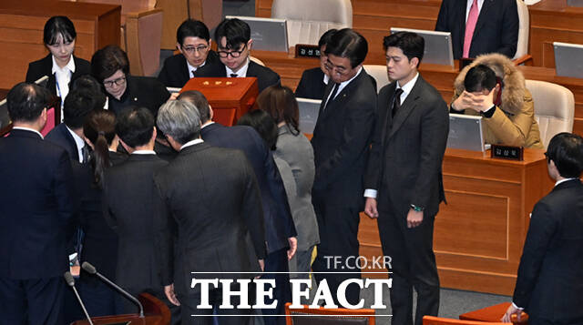 감표 위원들이 명패함과 투표함을 여는 가운데, 김상욱 의원이 고개를 떨군 채 결과를 기다리고 있다.