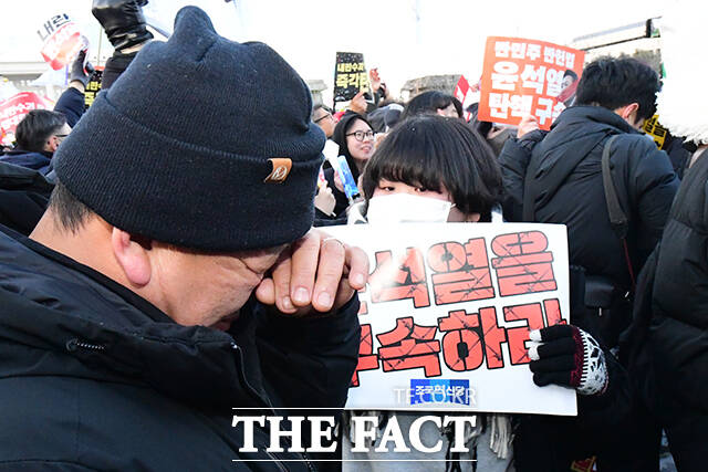 윤석열 대통령에 대한 탄핵소추안이 가결된 14일 오후 서울 여의도 국회 앞에서 열린 윤석열 즉각 탄핵 범국민 촛불대행진에 참가한 한 시민이 기쁨의 눈물을 흘리고 있다. /장윤석 기자