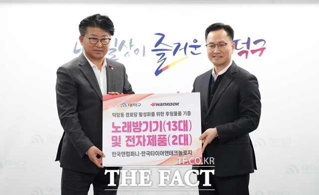 한국타이어가 24일 대전시 덕암동 경로당과 석봉동 노인회관에서 연말 물품 전달식을 진행했다. 이준길 한국타이어 대전공장장(오른쪽)과 최충규 대전시 대덕구청장이 기념 촬영을 하는 모습. /한국타이어