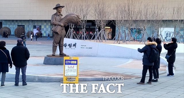 30일 동대구역 광장에 세워진 박정희 전 대통령 동상 앞에 행인들이 기념 사진을 찍고 있다. 동상 앞뒤에는 CCTV 쵤영 중, 낙서 훼손할 때는 처벌받을 수 있다는 안내판이 서 있다. / 박병선 기자