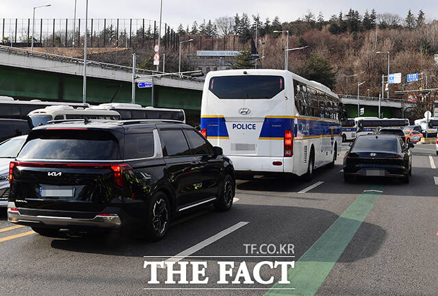 3일 오후 서울 용산구 대통령 관저 앞에서 공수처 수사 관계자를 태운 차량이 관저를 나서 지지자들 옆을 지나고 있다. /장윤석 기자