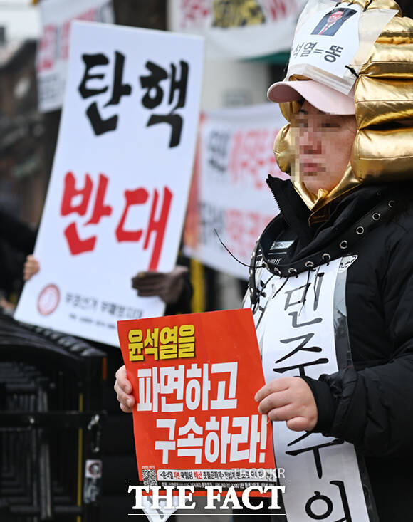 헌법재판소 앞에서 윤 대통령의 탄핵을 촉구하는 시민과 반대하는 시민들이 나란히 피켓 시위를 하고 있다.