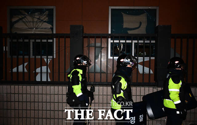 경찰들이 19일 오전 일부 윤석열 대통령 지지자들의 난동으로 입구와 창문, 외벽 등이 파손된 서울 마포구 서울서부지방법원 앞을 지나가고 있다. /이새롬 기자