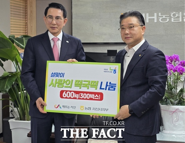 설맞이 사랑의 떡국떡 나눔 행사를 개최한 23일 농협 서산시 송연광 지부장(오른쪽)이 이완섭 서산시장에게 600kg의 떡국떡을 전달하고 기념촬영을 하고 있다./ 농협서산시지부