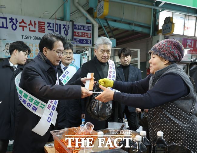 심덕섭 군수가 24일 설 명절을 앞두고 위축된 소비를 진작하고 지역경지역경제 활성화를 위해, 고창 전통시장에서 제수물품을 구입한 뒤 물건값을 치르고 있다./고창군