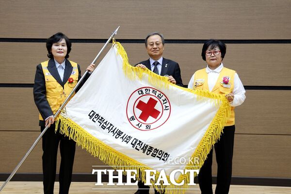 대한적십자사봉사회 대전세종협의회가 11일 정기총회 및 회장 이취임식을 개최했다. 송하영 대전·세종지사 회장(가운데)이 윤완순 이임 회장과 취임하는 제15대 이묘인 회장에게 적십자기를 전달하고 있다./대한적십자사봉사회 대전세종지사