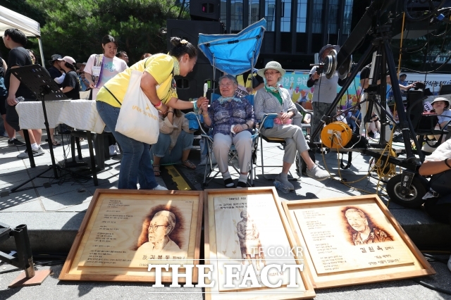 세계 일본군 위안부 기림일이자 74주년 광복절을 하루 앞둔 2019년 8월 14일 오후 서울 종로 옛 주한일본대사관 앞에서 열린 1400차 일본군 성노예제 문제해결을 위한 정기 수요집회 길원옥 할머니가 세월호 참사 희생자 가족과 인사하고 있다./더팩트 DB