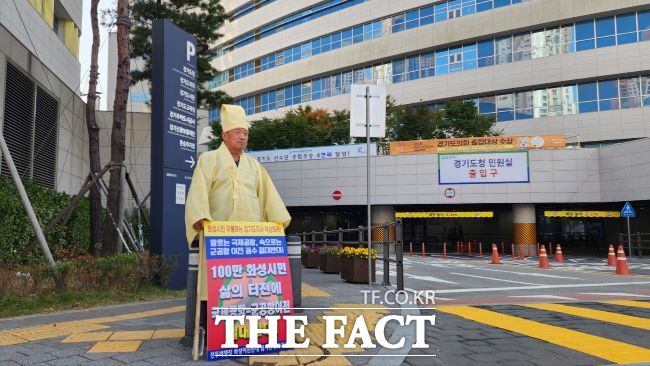 이상환 수원전투비행장 화성 이전 반대 범시민대책위원회 상임위원장이 상복 차림으로 100만 화성시민 삶의 터전에 국제공항·군공항이전 절대반대라고 적힌 피켓을 들고 1인 시위를 벌이고 있는 모습./범대위