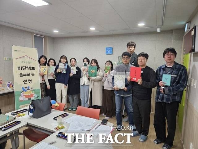 사서 선정단이 2025년 비단책보(올해의 책) 후보 도서에 오른 책을 들고 기념촬영을 하고 있다. /금산군