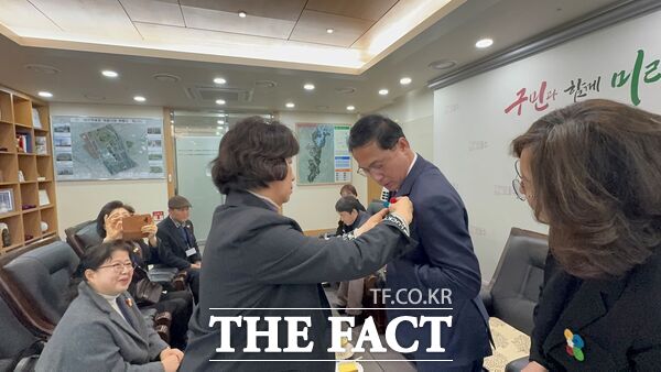 대전 동구행복한어르신복지관의 ‘행복한 동행 기자단’ 이 25일 출범식을 갖고 박희조 동구청장을 찾아 ‘동구의 바람’이 될 것을 약속하며 권선옥 기자가 직접 만든 동구의 바람개비를 형상화한 브로치를 박희조 청장에게 달아주고 있다../동구행복한어르신복지관