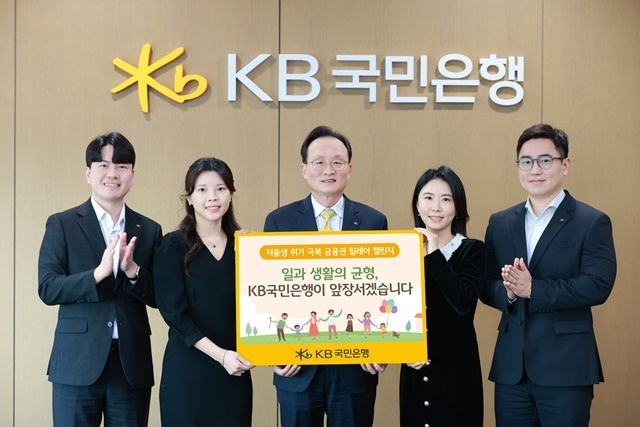 서울시 영등포구에 위치한 KB국민은행 신관에서 이환주 KB국민은행장(가운데)과 KB아이사랑적금를 기획한 KB국민은행 수신상품부 직원들이 저출생 위기 극복 챌린지에 참여해 기념 촬영을 하고 있다. /KB국민은행