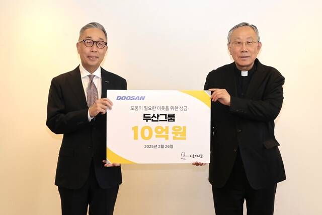 박지원 두산그룹 부회장(왼쪽)과 구요비 재단법인 바보의 나눔 이사장이 지난 26일 서울 명동성당에서 열린 성금 전달식에서 기념 촬영을 하고 있다. /두산그룹