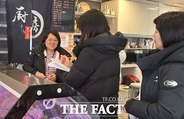 외국인 사업자에게 영업자 준수사항을 안내하는 외국인 인력풀 자원봉사자./부천시